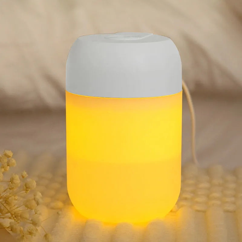 White cylindrical mini USB humidifier with aromatherapy function on a wooden surface.