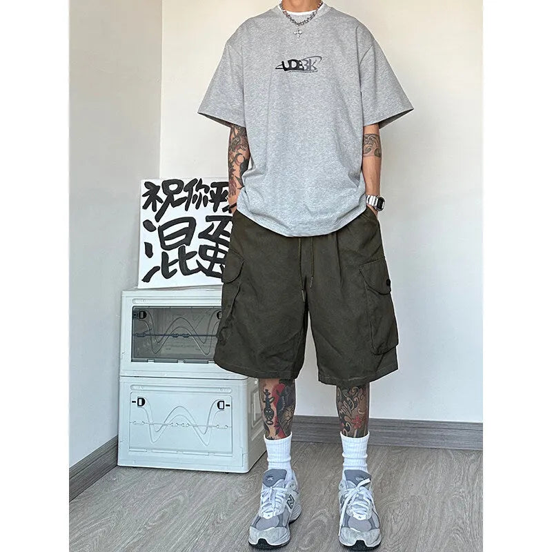 Loose straight-cut casual sports shorts in polyester, shown in khaki colour on a hanger.