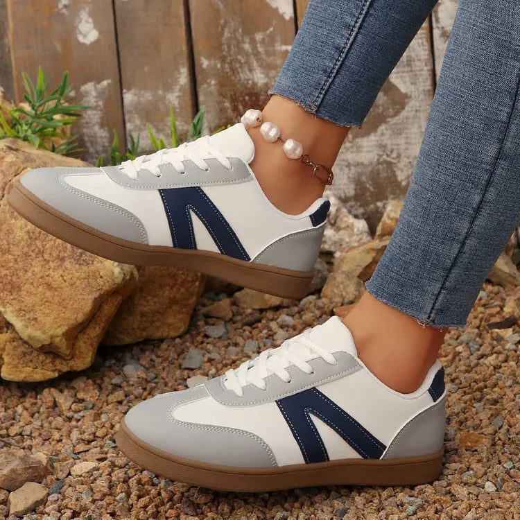Blue women's low-top flat training shoes with lace-up front and rubber sole.