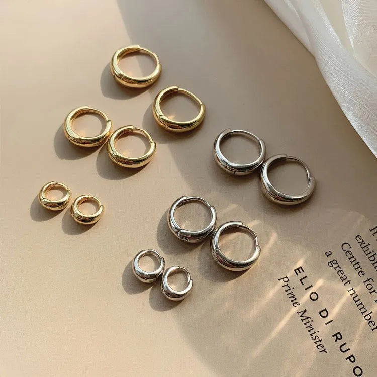 Women's minimalist copper water drop earrings in gold and silver, shown in large, medium, and small sizes.