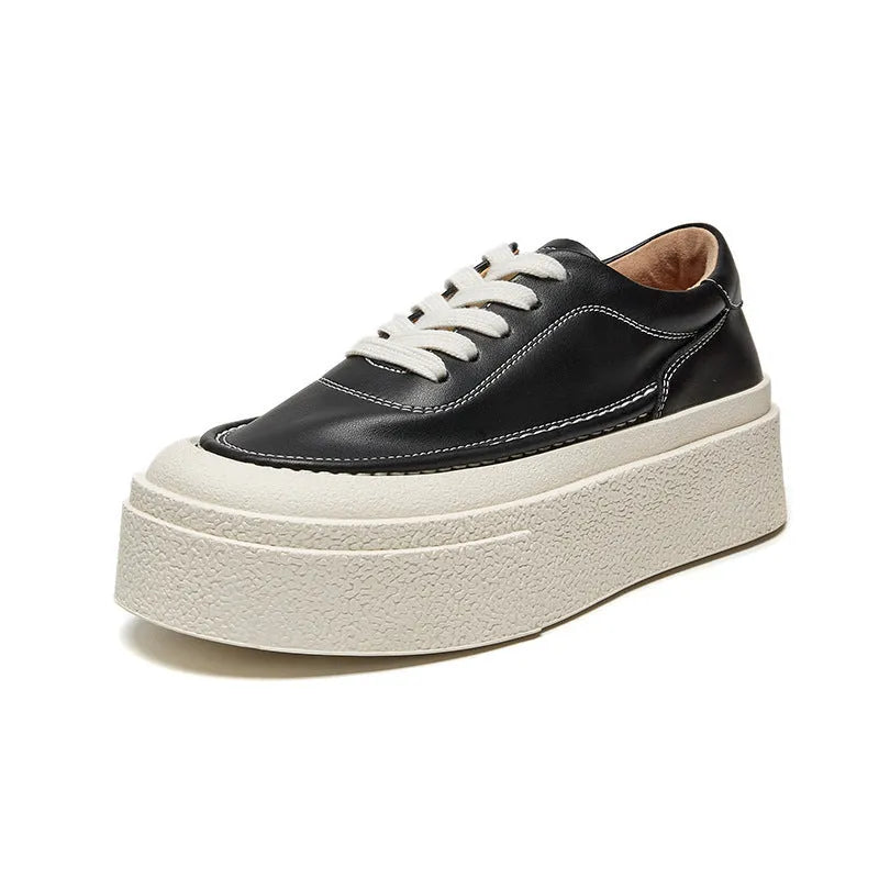 Black and white women's embossed leather platform sports shoes with a round toe and rubber sole.
