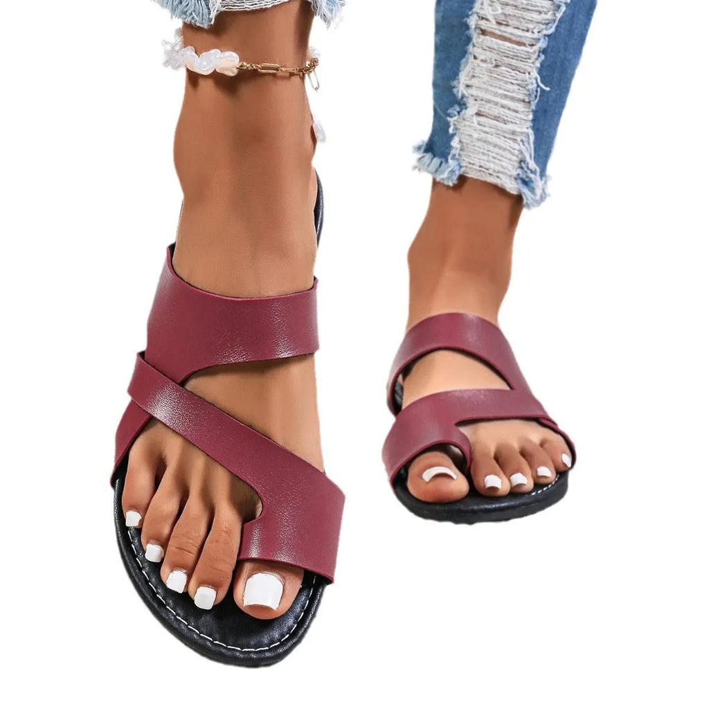 Casual beach slipper in black with round head, one-line design, and hollow-out pattern on artificial PU upper.