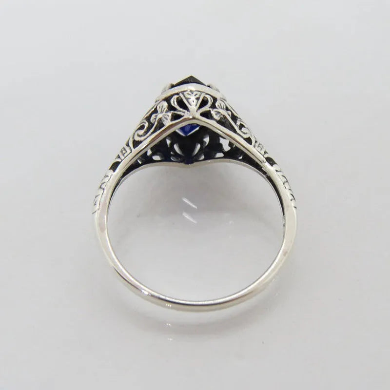 Silver geometric hollow women's ring on grey background showing detailed pattern