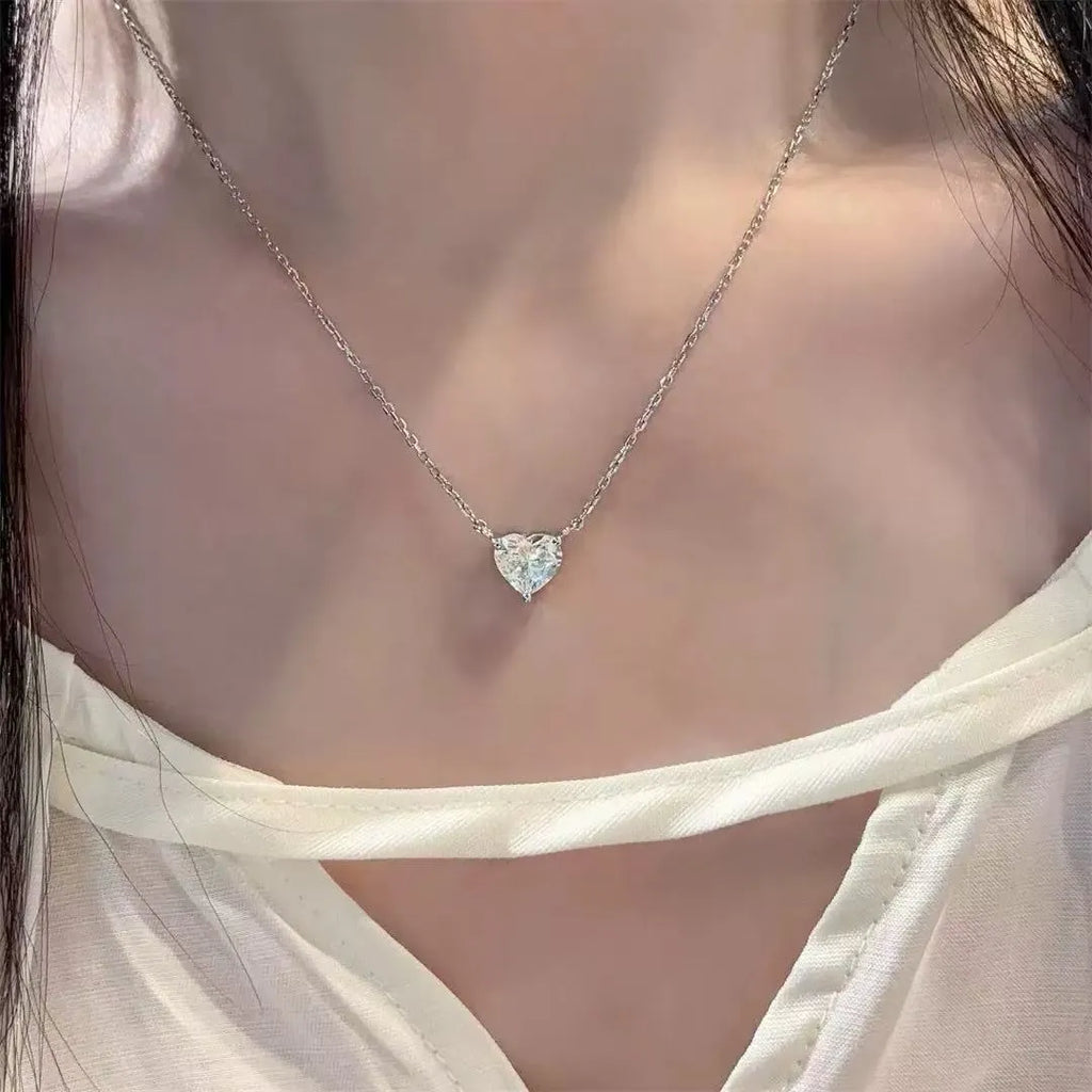 Silver-coloured women's necklace with a simple heart-shaped pendant on a chain.