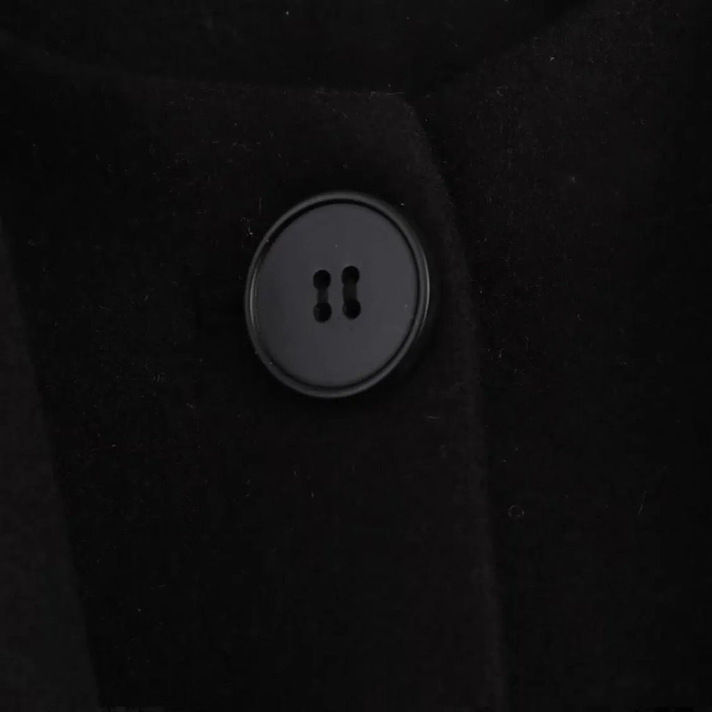 Women's long black polyester blend overcoat with a detachable artificial fur collar, showing pocket detail and street-fashion fit.