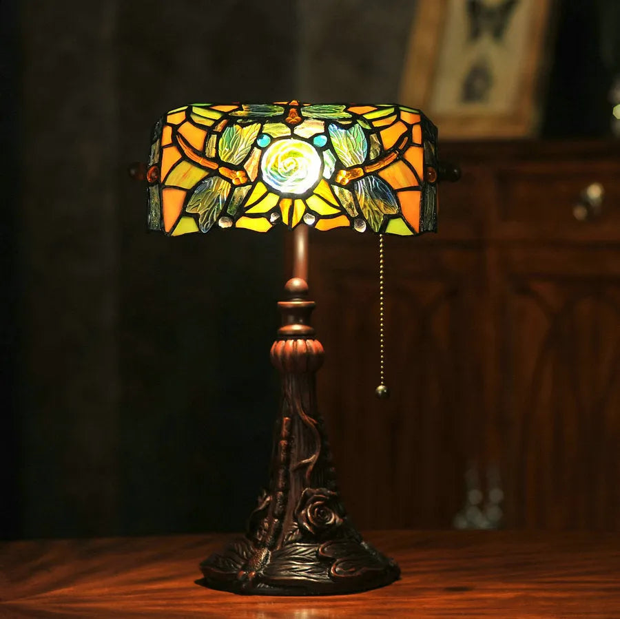 Tiffany table lamp with stained glass shade on wooden desk, 36cm tall with warm lighting