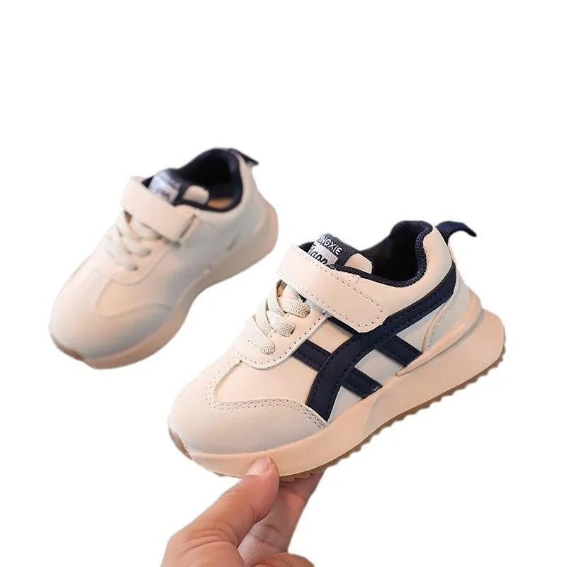 Children's white synthetic leather sneaker with Velcro strap and rubber sole.