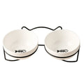 White ceramic cat bowl with cat paw print in a black iron frame stand with cat ears.