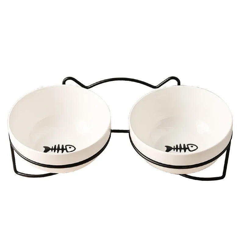 White ceramic cat bowl with cat paw print in a black iron frame stand with cat ears.