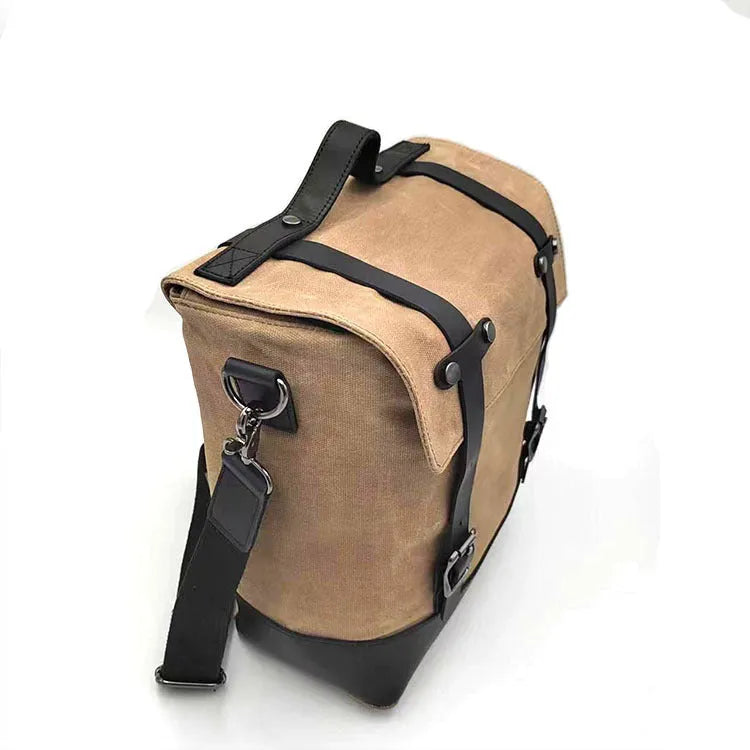 Black waterproof canvas motorcycle side pannier bag with cowhide reinforcement mounted on motorcycle