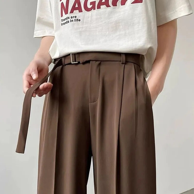 Men's black loose straight-leg trousers with a non-ironing finish on a hanger