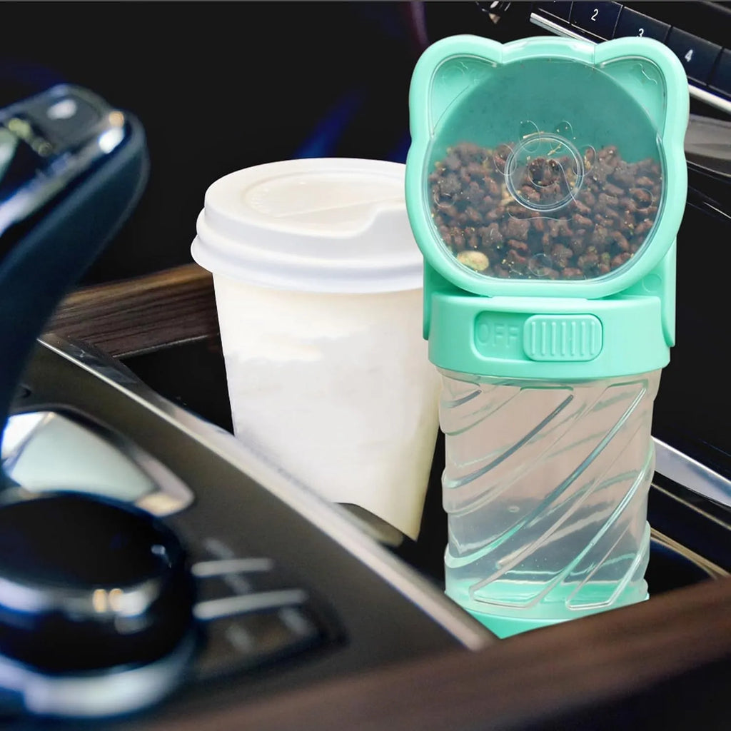 Green 3-in-1 portable pet water bottle with food pot and waste bag dispenser attached to a hand strap.