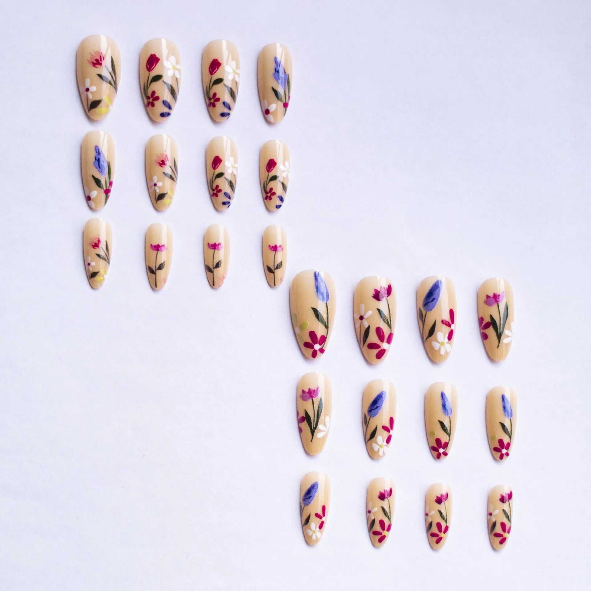 Almond-shaped removable false nails with rose and tulip floral designs on a solid colour background.