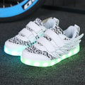 Children's plum red and white LED light-up sneakers showing flashing soles and USB charging cable.