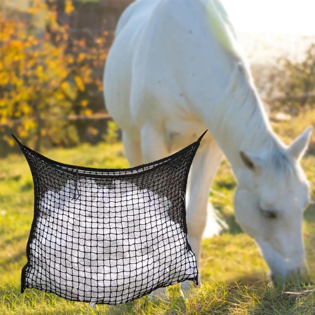 Black woven PE rope grid feeding bag hung on a fence, suitable for horses and cattle.