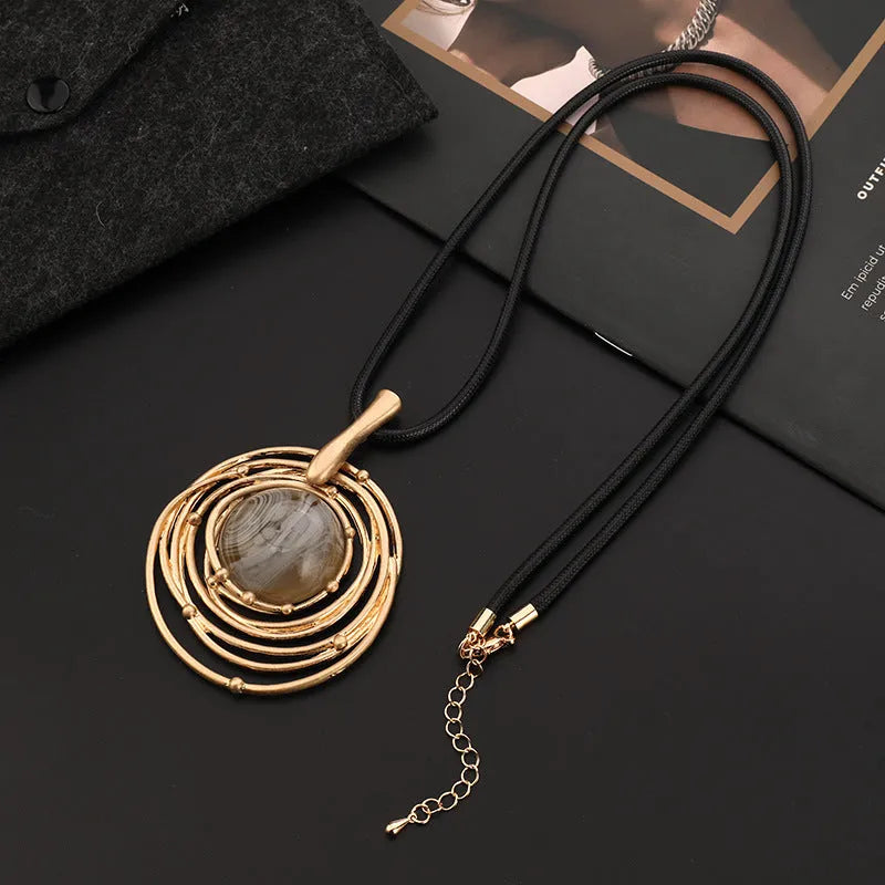 Vintage gold women's necklace with large round plaid pendant on a snake skin chain, shown at adjustable length.