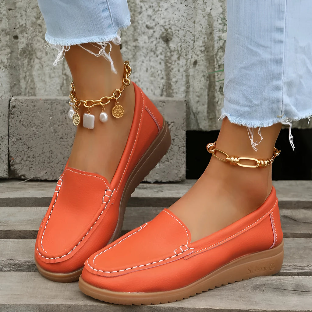 Women's white PU leather slip-on loafer flats with round toe and rubber sole on a plain background.