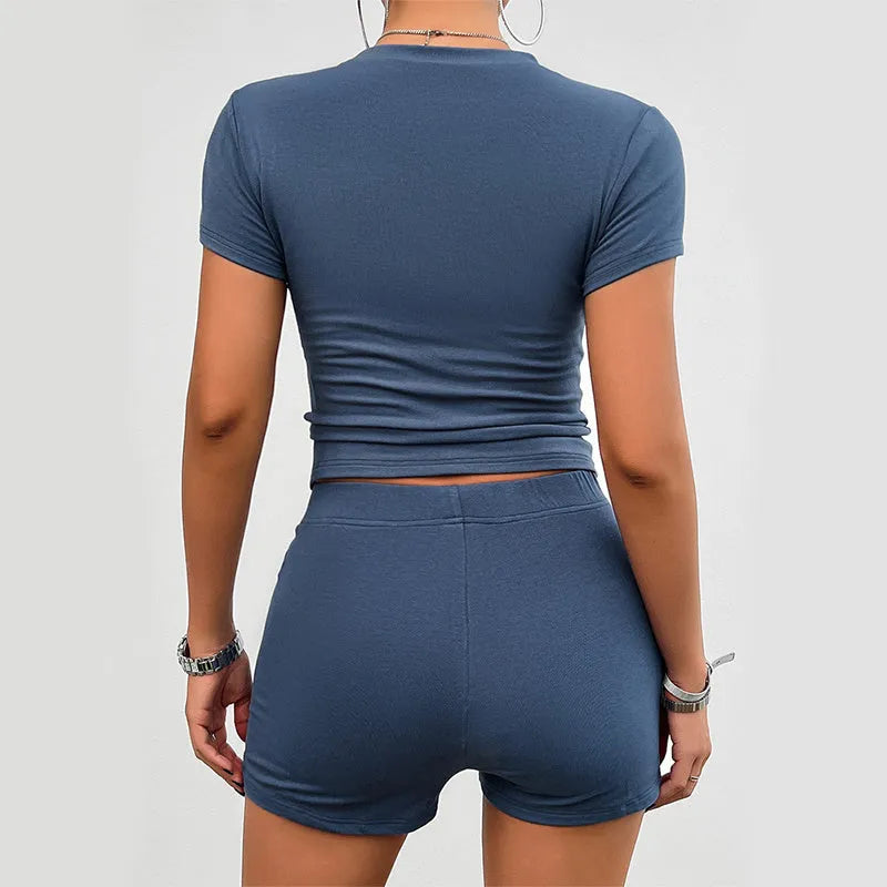 Womans solid colour slim-fit two-piece sport set with short sleeve t-shirt and elasticated shorts.