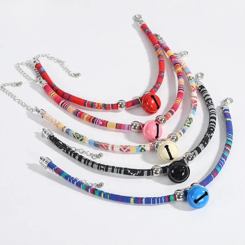 Coloured ethnic-style adjustable pet collar for dogs and cats with a small bell, shown in multiple colour options.