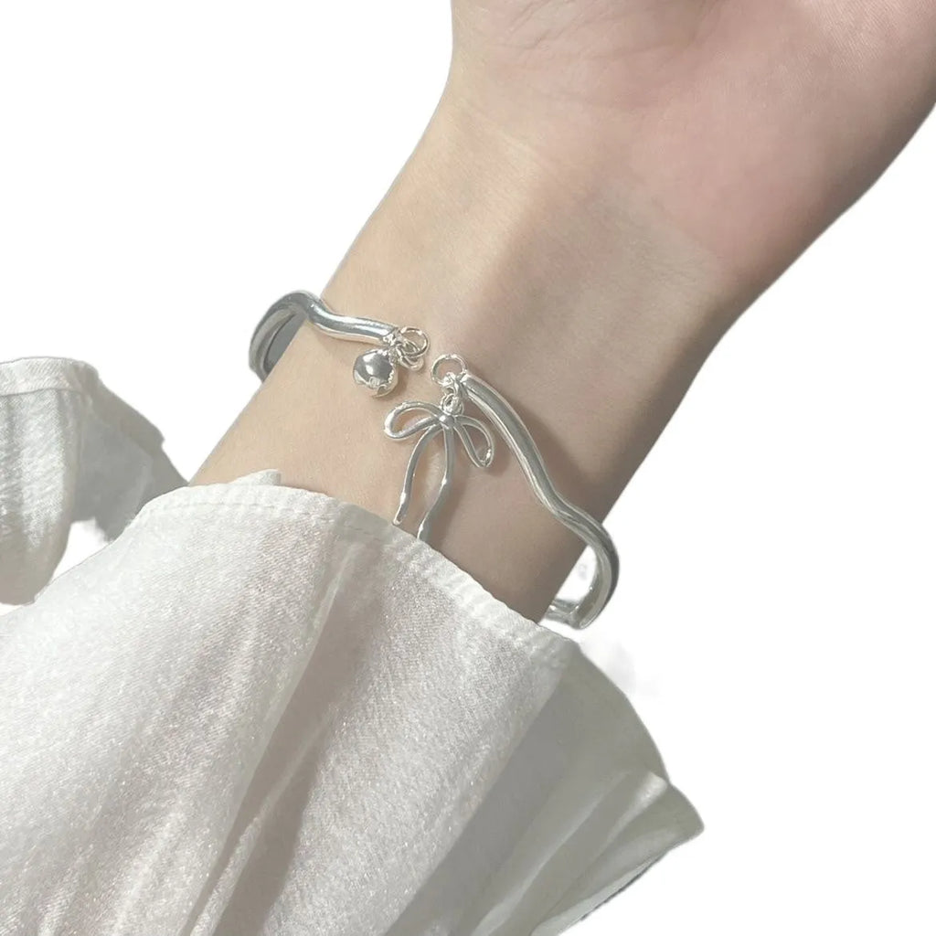 Silver adjustable bow bracelet with bell opening mechanism on zinc alloy chain
