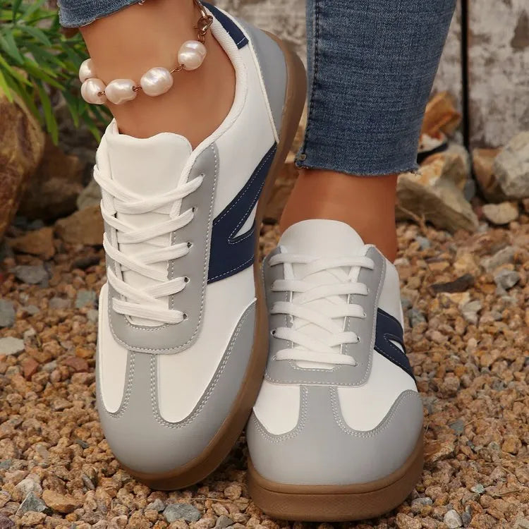 Blue women's low-top flat training shoes with lace-up front and rubber sole.