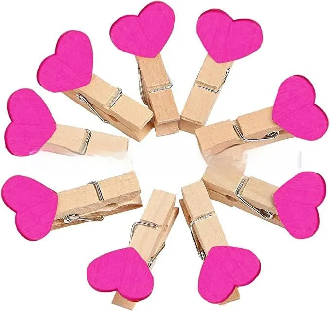 Set of five handmade solid wood heart-shaped clips in red, pink, white, and yellow on a wooden surface.