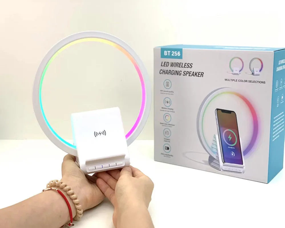 White smart Bluetooth speaker with ambient light and 15W wireless charging pad on desk