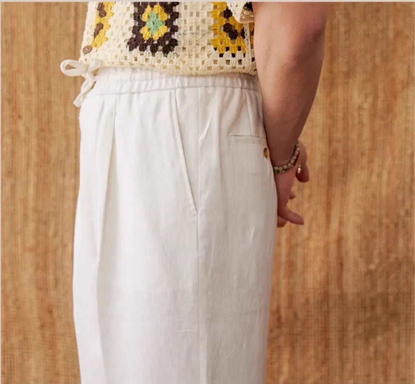 Linen high waist trousers with elasticated waistband in a straight-leg fit on a hanger.