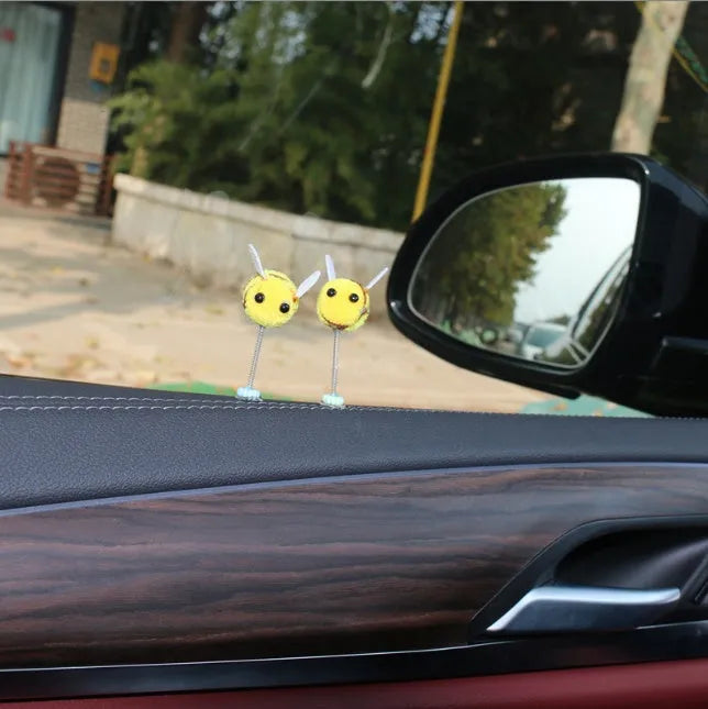 Soft fur bee car decoration on a swing spring for dashboard personalisation.