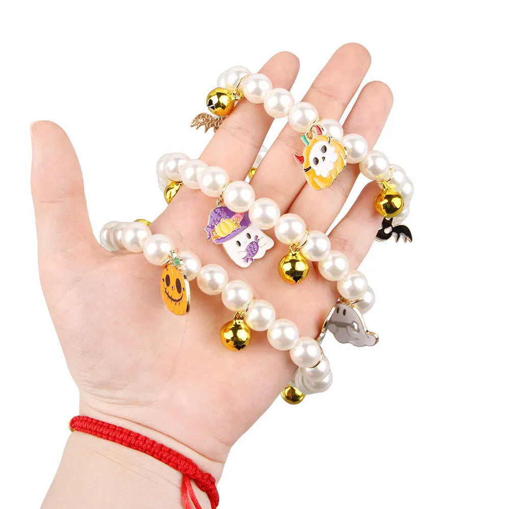 Halloween cat collar decoration with simulated pearls in purple ghost, skull, and smiling pumpkin designs.