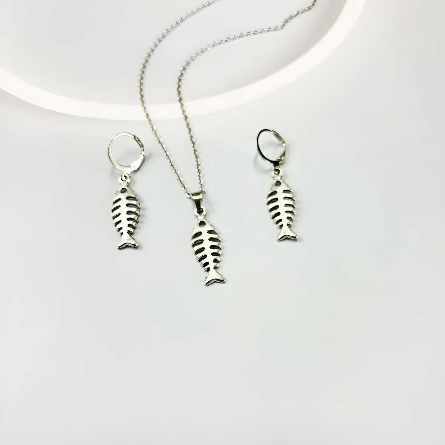 Fishbone pendant earrings and matching necklace set with adjustable chain on grey background