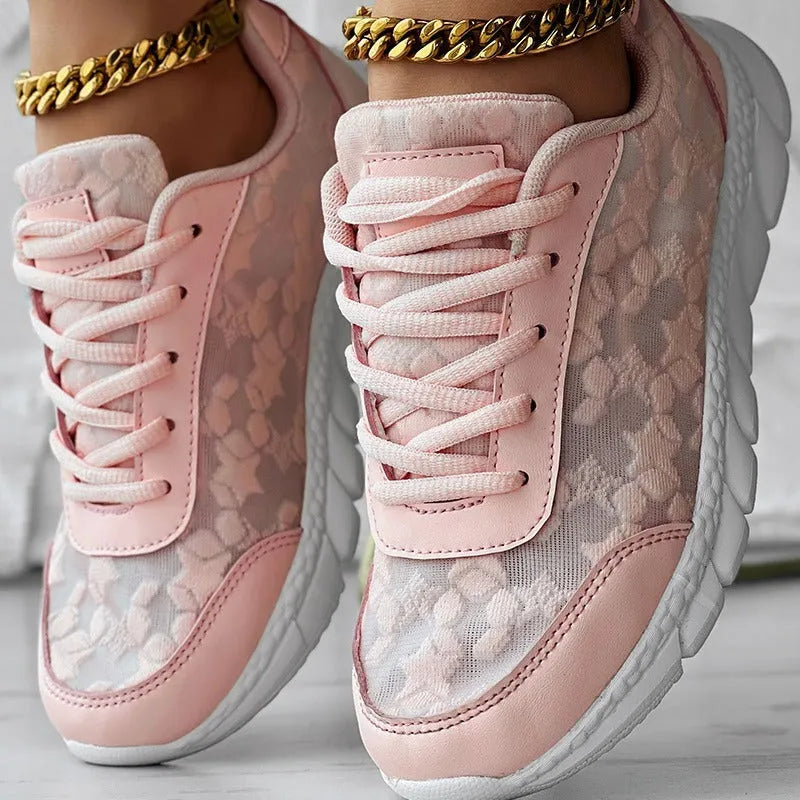 Women's white canvas sports shoes with round toe and flat heel on a neutral background.