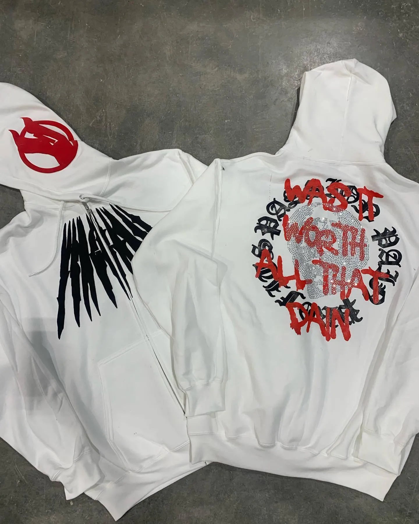Black loose hooded cardigan sweatshirt with white printed skull letter pattern and rhinestone details.