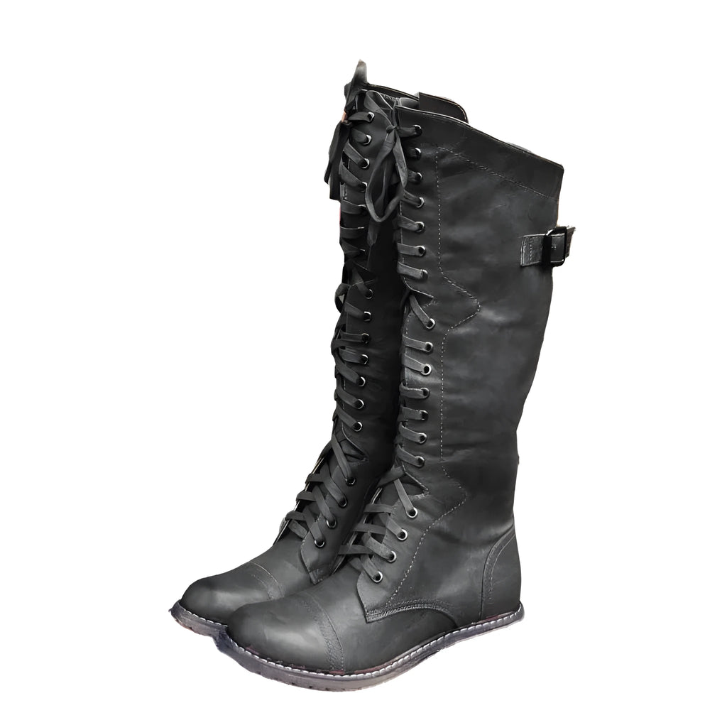 Women's black cross strap knight boots made from artificial PU, showing the ankle strap detail.