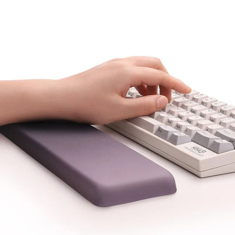 Square blue cloth silicone wrist rest mouse pad on a desk.