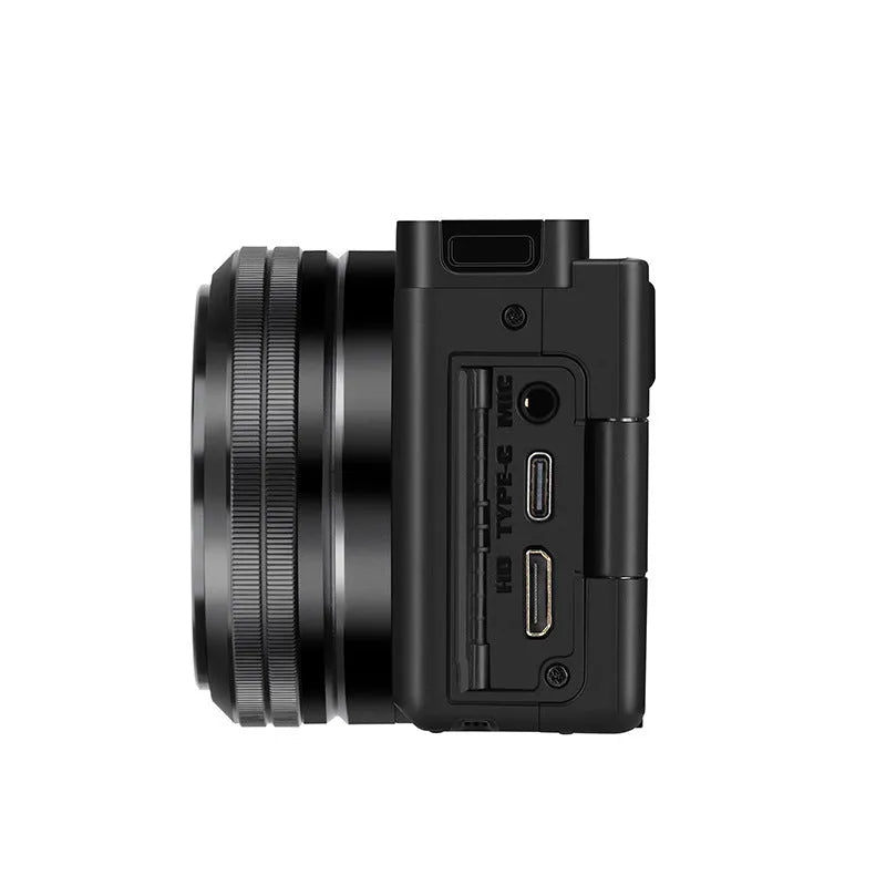 Optical digital micro single camera in black with ultra wide angle lens, touch screen, 117x84x66mm, sling attached, on travel background