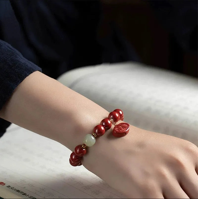 Natural cinnabar Emperor Sandstone Ping An Fu Lu bracelet with red beads.