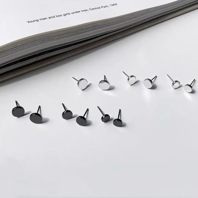 A pair of flat, round S999 sterling silver stud earrings on a plain background.