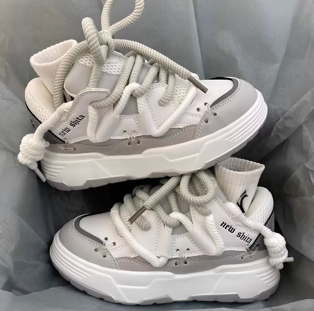 Grey women's chunky lace-up sneakers with a thick rubber sole and retro design on a white background.