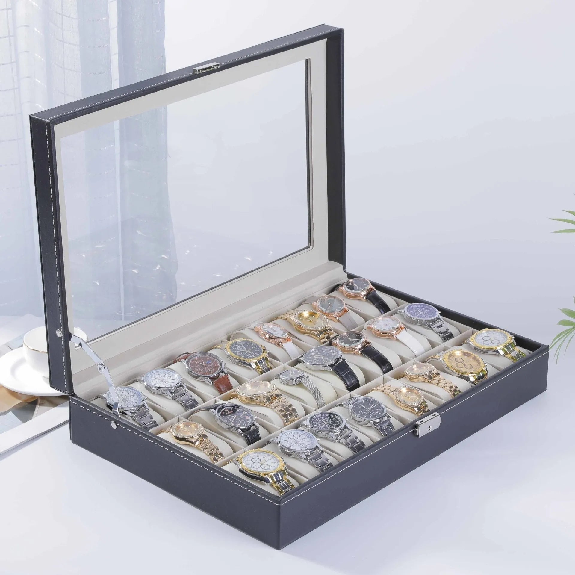 Grey leather watch storage box with clear dustproof lid showing multiple watch compartments inside.