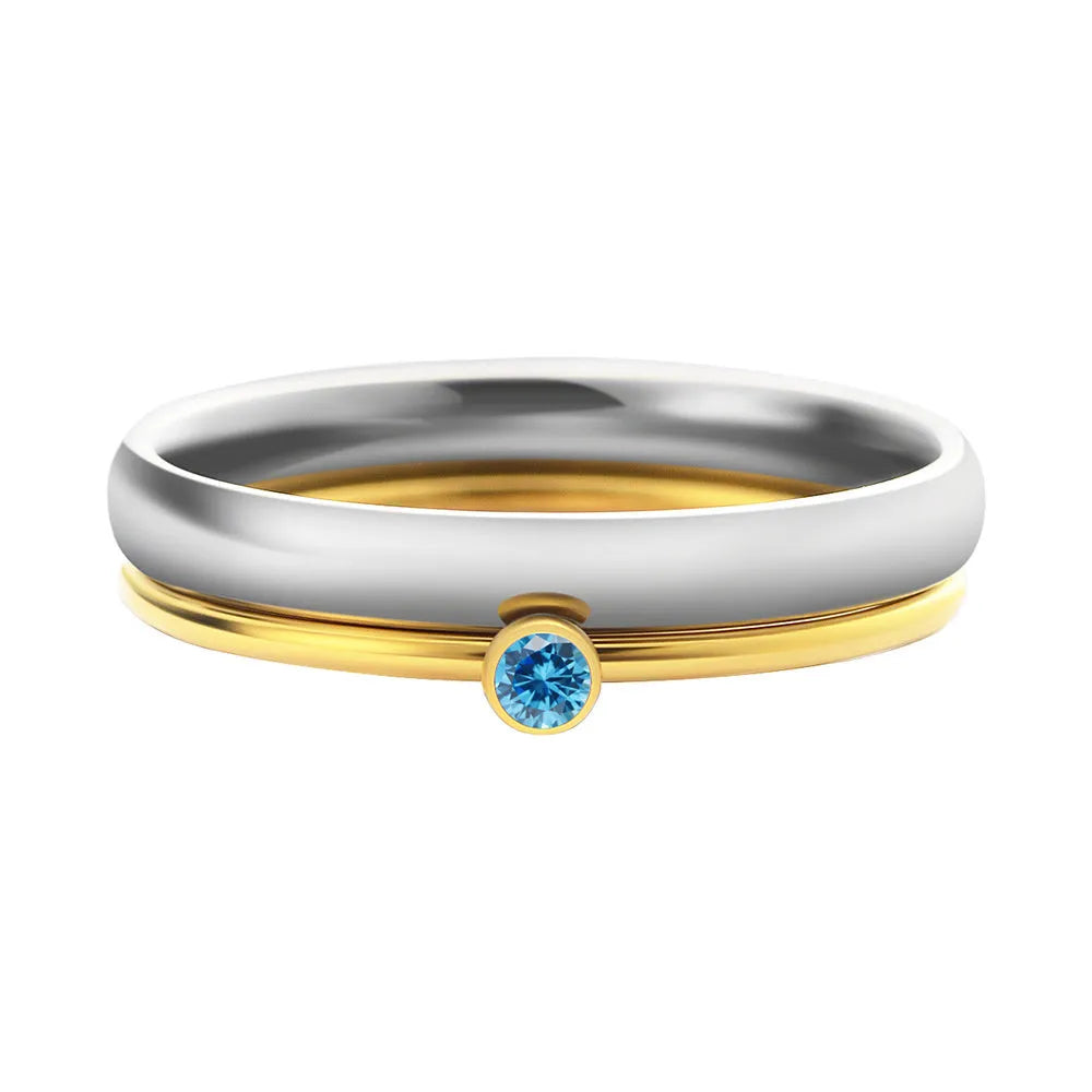 December birthstone geometric engraved ring in titanium steel with gold-coloured handle on a grey background.
