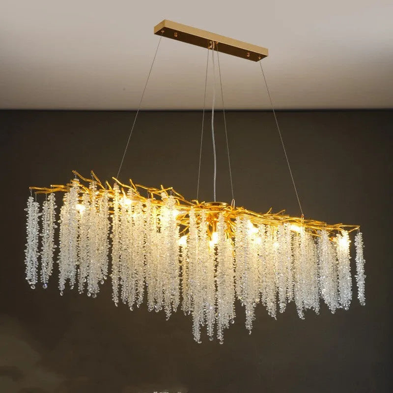 Modern crystal chandelier light with adjustable chain above a dining table.