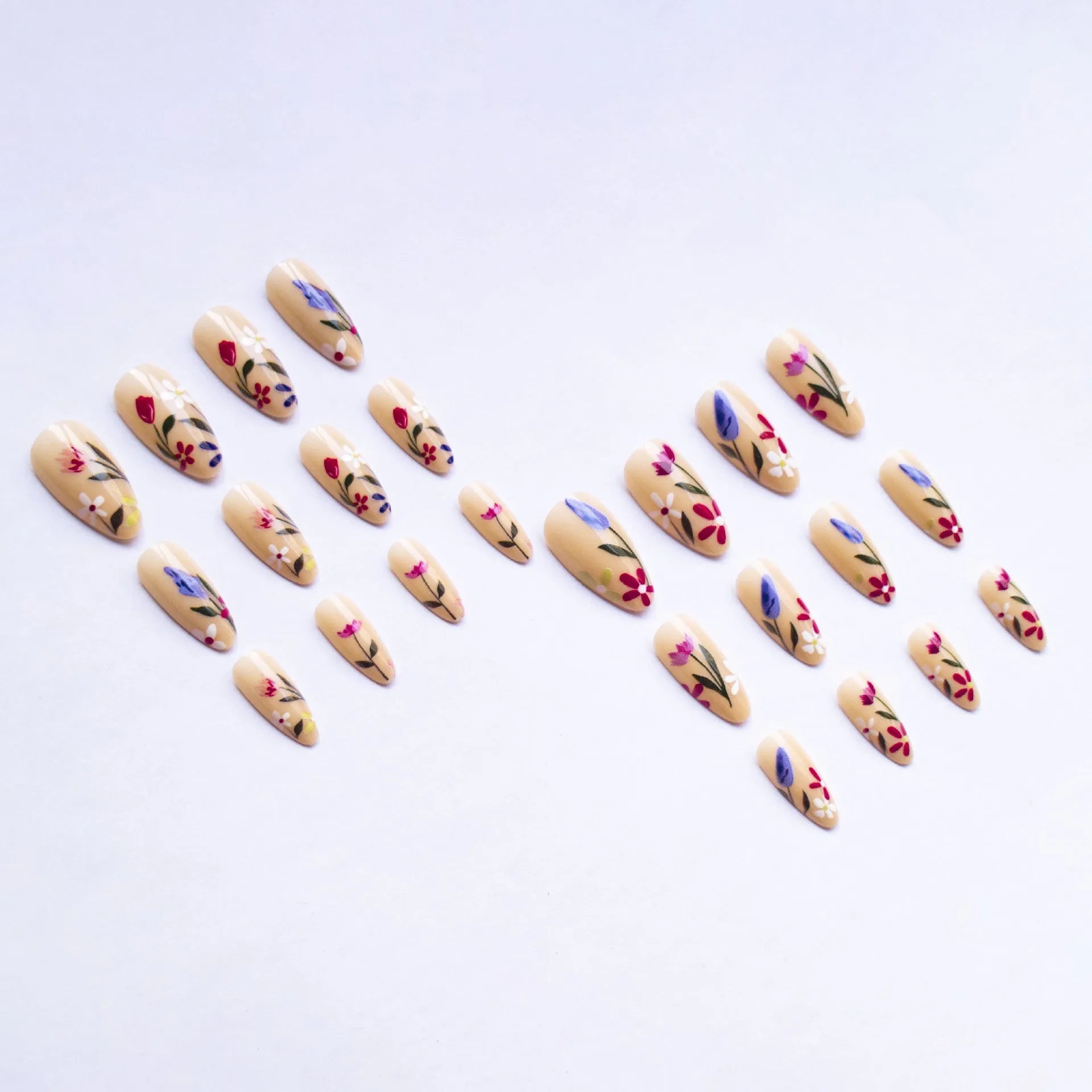 Almond-shaped removable false nails with rose and tulip floral designs on a solid colour background.