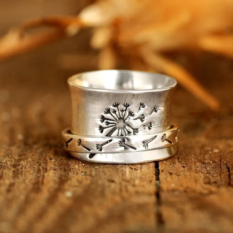 Rotatable silver-colour flower ring showing adjustable design on finger