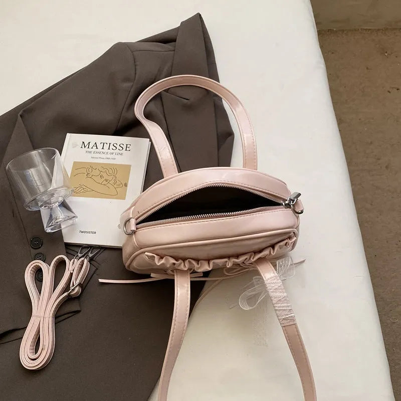 Women's fashion shoulder handbag with bandage bow design in PU leather showing interior phone pocket